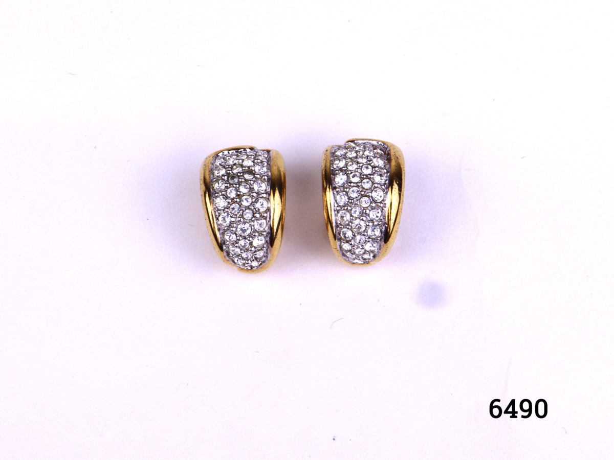 Vintage Swarovski clip-on earrings in gilt metal encrusted with Swarovski crystals Measures 20mm by 10mm Both clips in good order Main photo of earrings displayed on a flat surface showing crystals