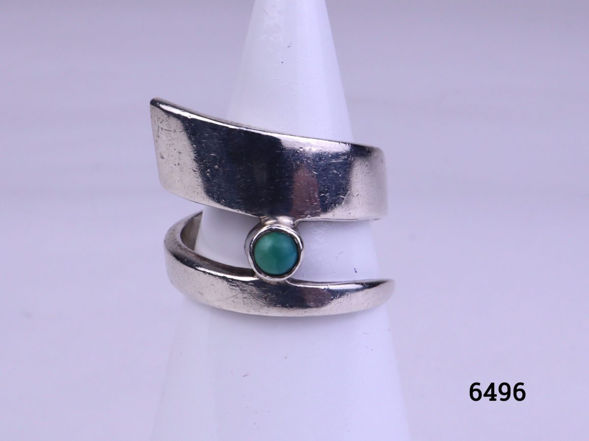 Modernist style vintage silver ring. Vintage sterling silver ring in an asymmetrical twist design with single small turquoise stone accent Size M.5 / 6.5 Main photo showing ring front displayed on a stand