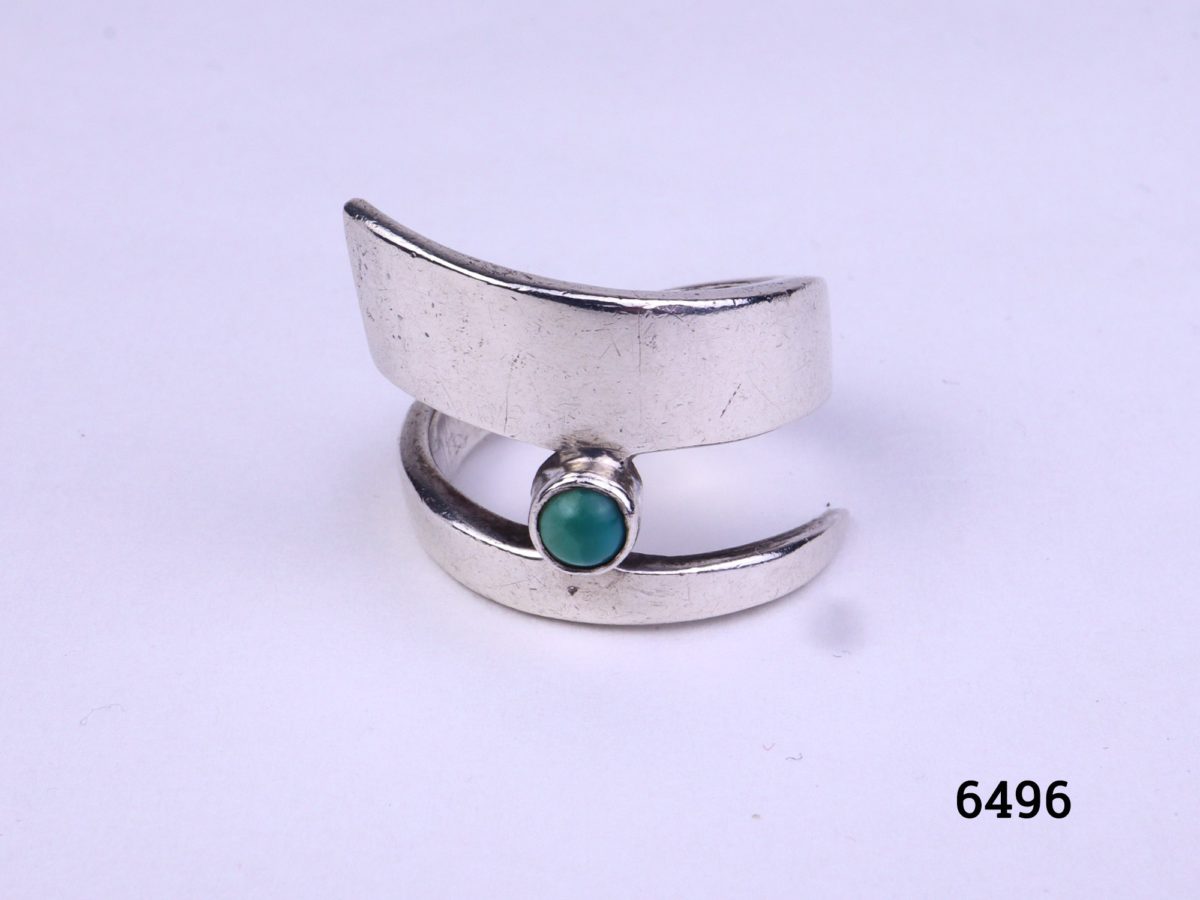 Modernist style vintage silver ring. Vintage sterling silver ring in an asymmetrical twist design with single small turquoise stone accent Size M.5 / 6.5 Photo of front of ring on a flat surface