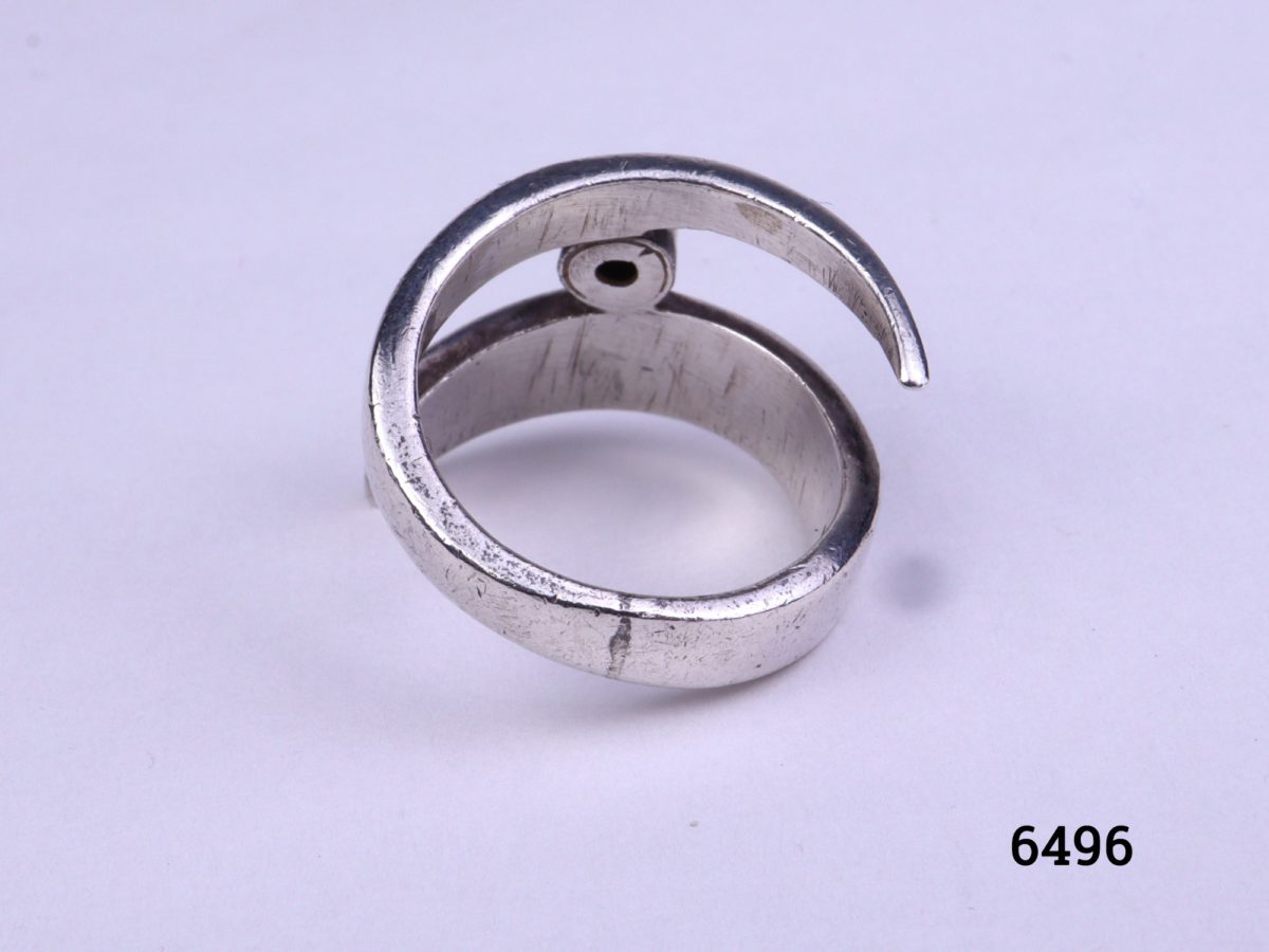 Modernist style vintage silver ring. Vintage sterling silver ring in an asymmetrical twist design with single small turquoise stone accent Size M.5 / 6.5 Photo of ring on a flat surface from back view