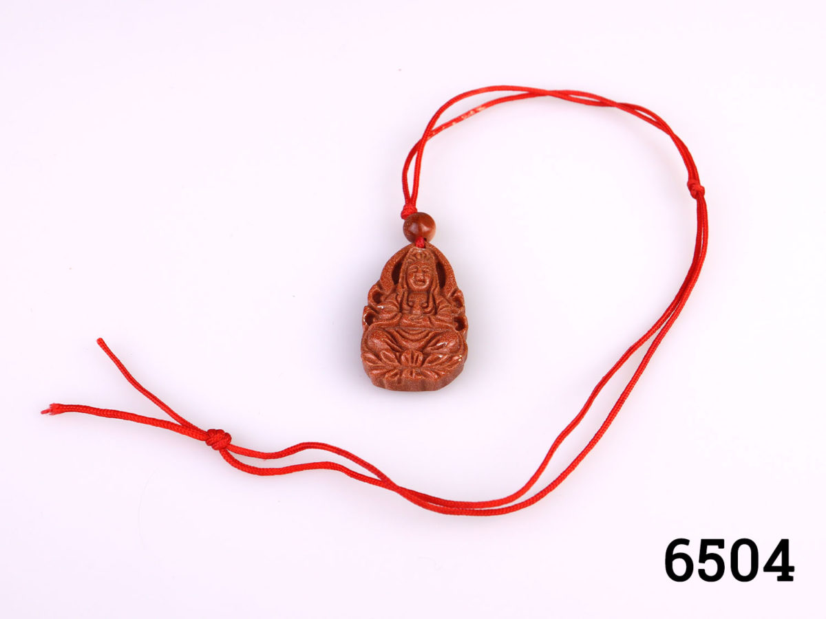 Vintage carved goldstone charm pendant of Guan Yin (The Buddhist Bodhisattva of compassion) Strung on customary red string Charm measures 32mm long by 20mm wide Main photo showing charm with whole length of red string