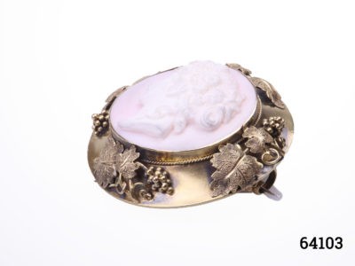 Victorian carved pink conch shell cameo of a lady in rare ornate mount decorated with grapes and vines in original box. Not hallmarked but tests for 18karat gold. Weighs 13.8 grams and measures 43mm in diameter Photo of brooch laid flat and facing upward and seen diagonally with cameo figure facing top left of photo