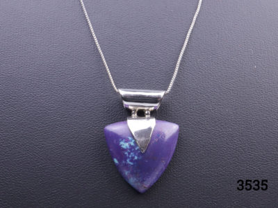 1980s vintage magenta turquoise pendant set on solid silver mount with sterling silver fine Italian chain. Both chain and pendant stamped 925 for sterling silver. Pendant drop length 30mm. Close up front view photo of the magenta turquoise pendant showing the flecks of natural turquoise colour mixed in