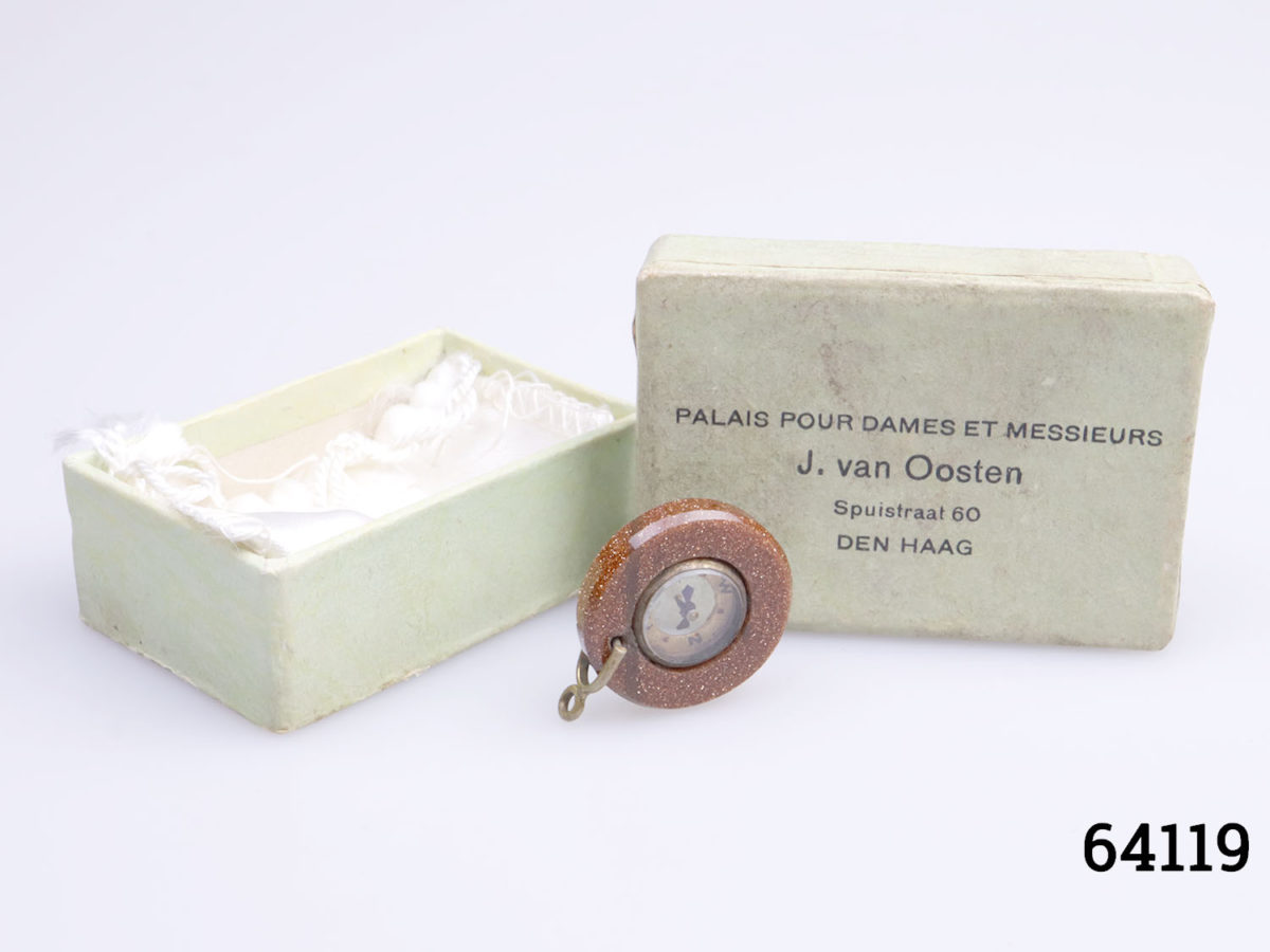 Antique goldstone compass fob. Miniature compass set in a ring of sparkly goldstone and mounted on brass. Comes in box and pouch. Measures 20mm in diameter and weighs 3.6g. Photo of fob displayed outside on box