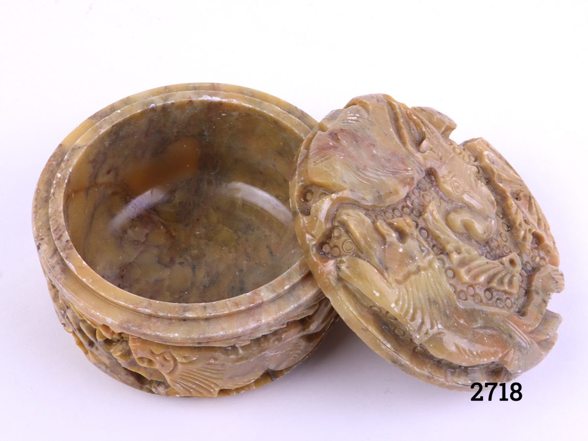 Carved soapstone lidded pot decorated with lion and elephant to the lid and lions and deer to the sides Measures 80mm in diameter Photo of pot with lid removed and leaning up against the pot and peering into interior