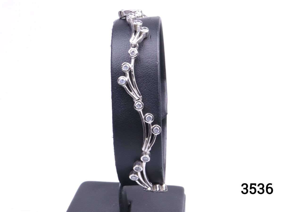 Vintage 925 sterling silver bracelet set with small cubic zirconia pieces in a wave like form. Hallmarked 925 Main photo showing bracelet displayed on a stand seen from the front