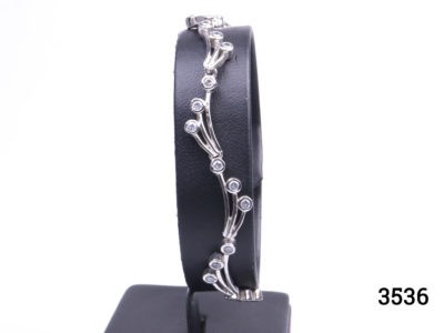 Vintage 925 sterling silver bracelet set with small cubic zirconia pieces in a wave like form. Hallmarked 925 Main photo showing bracelet displayed on a stand seen from the front