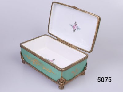19th Century Paris porcelain box. Hand-painted box in sea green with floral design to centre of the lid with ormolou gilt metal edging and brass feet. Hand-painted picture signed by Renan Photo of box set at a diagonal angle seen with lid open showing the minimal interior decoration