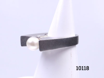 Chunky Modernist style sterling silver ring set with pearl to the centre and cubic zirconia to the sides below the pearl. Ring size P / 7.5. Ring weight 11.9 Photo of ring on a display stand shown from a side angle