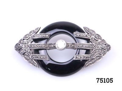 Art Deco style sterling silver and marcasite brooch with a ring of jet to the centre. Will be sent boxed. Brooch measures 62mm long by 35mm wide and weighs 17.7 grams Main photo showing close up image of brooch front