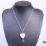 925 Sterling silver chain with a rock quartz crystal heart. A smaller clear crystal heart attached below the quartz heart. Pendant drop length 43mm. Main hoto of necklace on a display stand looking straight on