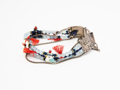 Costume jewellery bracelet with seagulls. Lovely bracelet depicting a seaside theme with 2 seagulls in sailing caps on either side of a life ring. Blue crystals gives it an 'at sea' look with nice blue and red thread work to accentuate the design. Interesting clasp with safety chain closure. Made in France by Taratata. Bracelet width approximately 20mm. Photo of bracelet on a flat surface with clasp done up