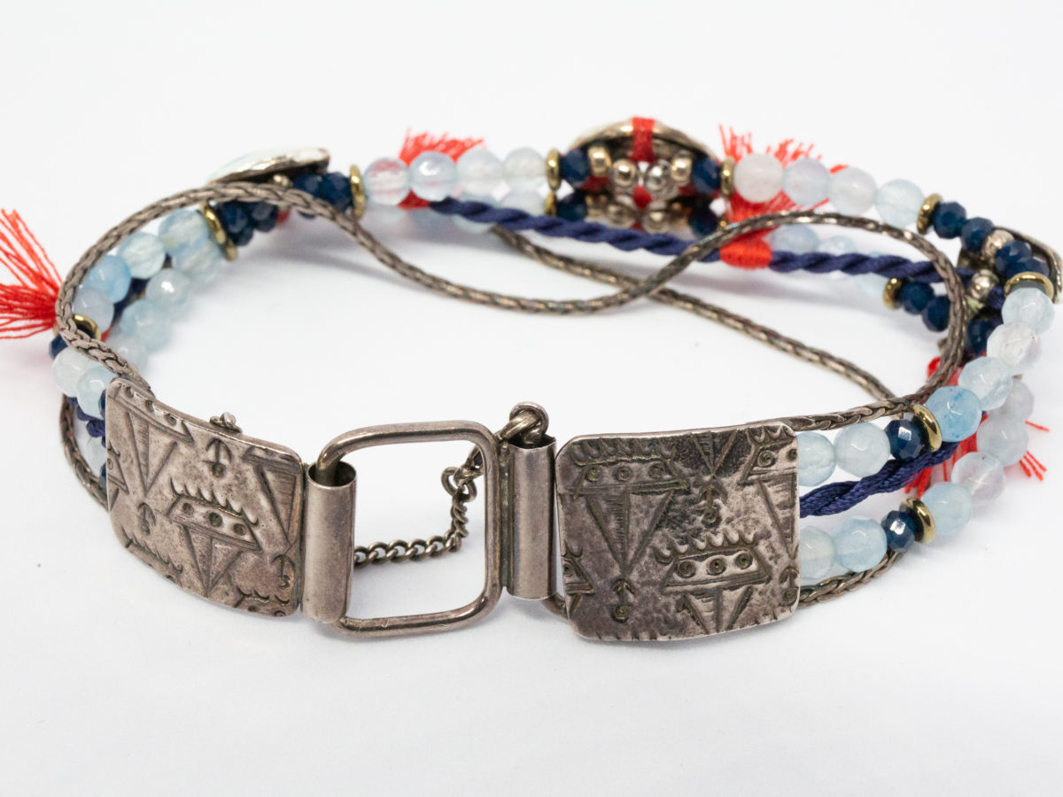 Costume jewellery bracelet with seagulls. Lovely bracelet depicting a seaside theme with 2 seagulls in sailing caps on either side of a life ring. Blue crystals gives it an 'at sea' look with nice blue and red thread work to accentuate the design. Interesting clasp with safety chain closure. Made in France by Taratata. Bracelet width approximately 20mm. Photo of clasp when bracelet done up
