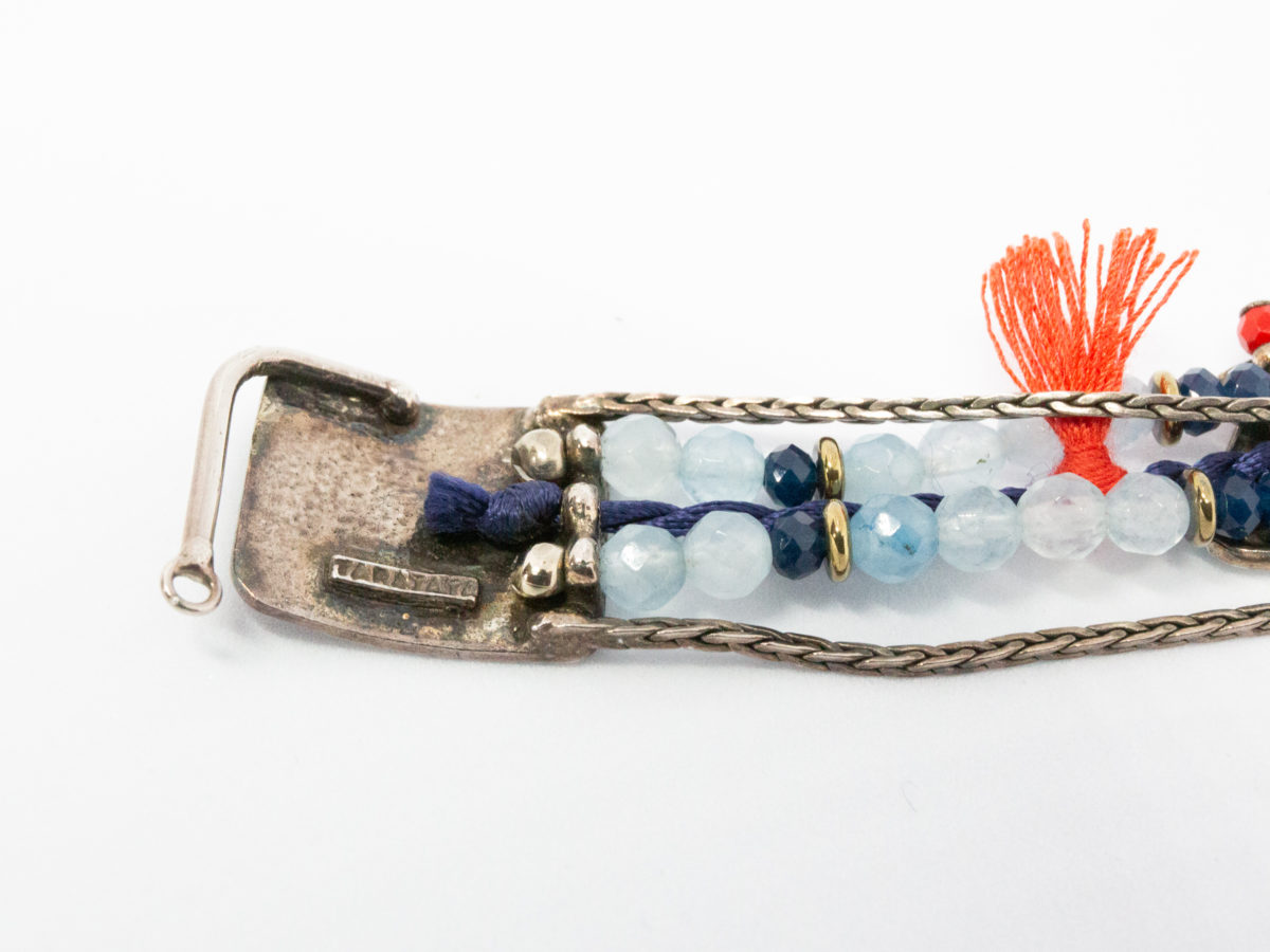 Costume jewellery bracelet with seagulls. Lovely bracelet depicting a seaside theme with 2 seagulls in sailing caps on either side of a life ring. Blue crystals gives it an 'at sea' look with nice blue and red thread work to accentuate the design. Interesting clasp with safety chain closure. Made in France by Taratata. Bracelet width approximately 20mm. Close up photo of the pin end of clasp