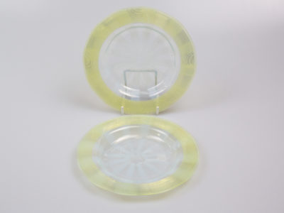 Pair of Art Deco glass side dishes. Handmade small shallow dishes with an unusual colour pattern of pale blue star burst to the centre and yellow green rim. Some minor signs of wear. Each dish measures approximately 100mm in diameter at base, 165mm across the top and 15mm in depth. Main photo showing one dish upright on a stand and other laid flat in front