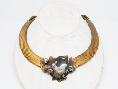 Vintage designer necklace by Ermani Bulatti. Striking design mix of Art Deco and Art Nouveau. Gilt metal choker style necklace with a bronzed leaf to the front set with a large acrylic smoky stone to the centre with Swarovski crystal to either side. Necklace is adjustable from 400mm to 485mm long. Main photo of necklace on a display stand