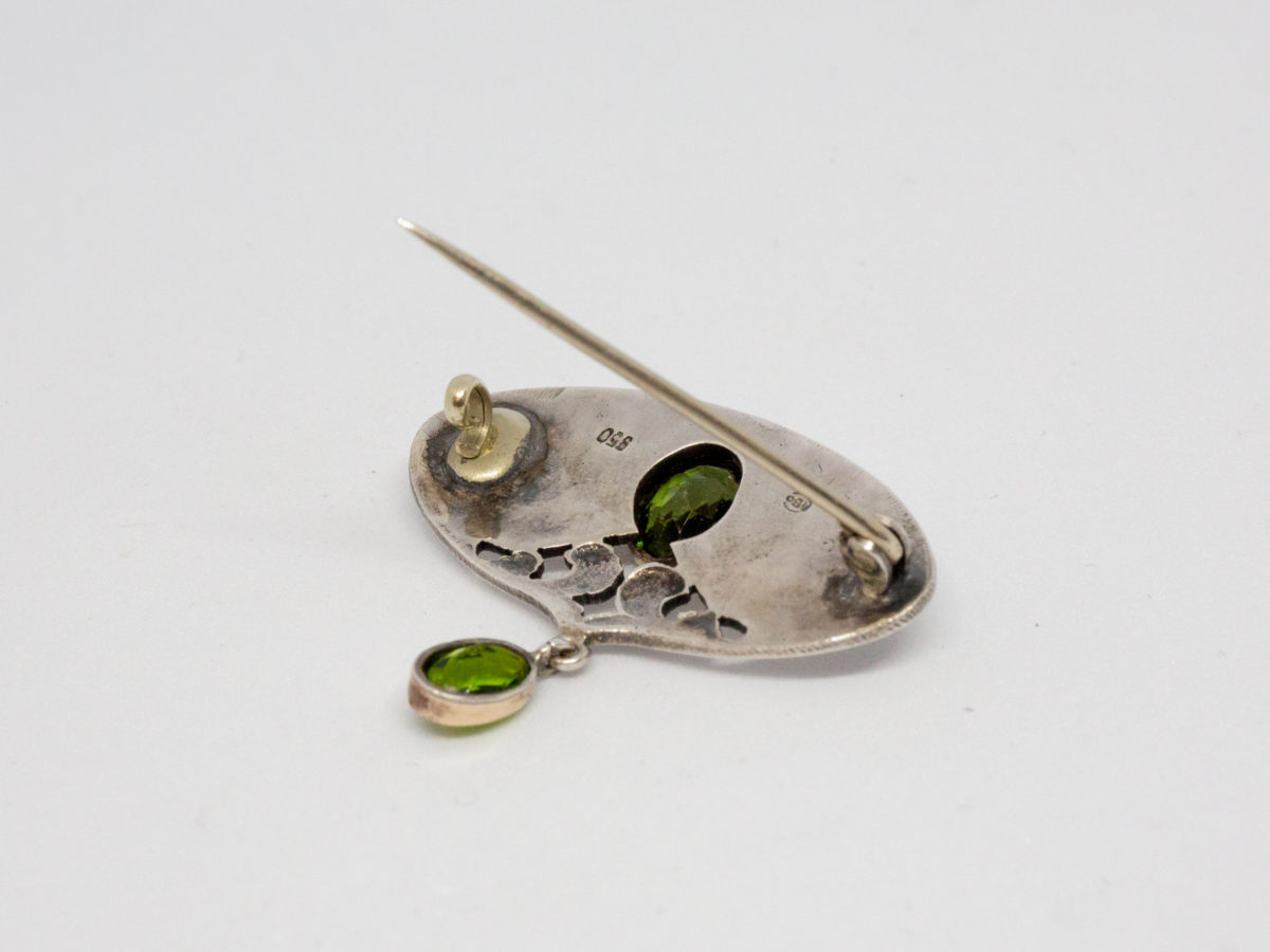 Art Nouveau brooch in 950 grade silver and peridot. Fine Art Nouveau brooch by Murrle Bennett & Co in a classic Art Nouveau design with 2 oval cut peridot stones. Hallmarked to the back. Photo of back of brooch with pin open