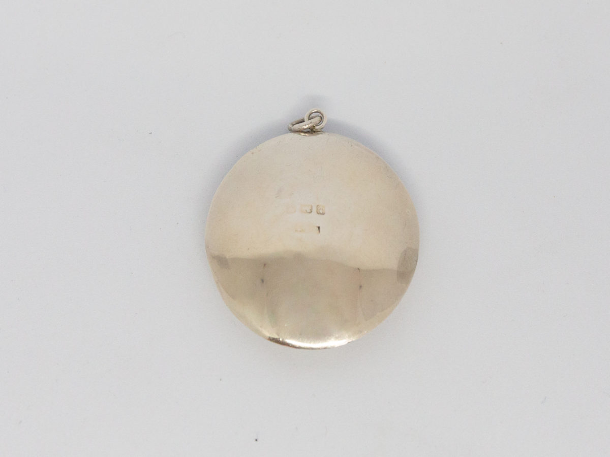 Small circular sterling silver compact. Vintage Art Deco chateleine compact with mirror and puff. Hallmarked for Birmingham assay (date stamp not readable). Measures 45mm in diameter. Photo of back of compact showing the worn hallmark.