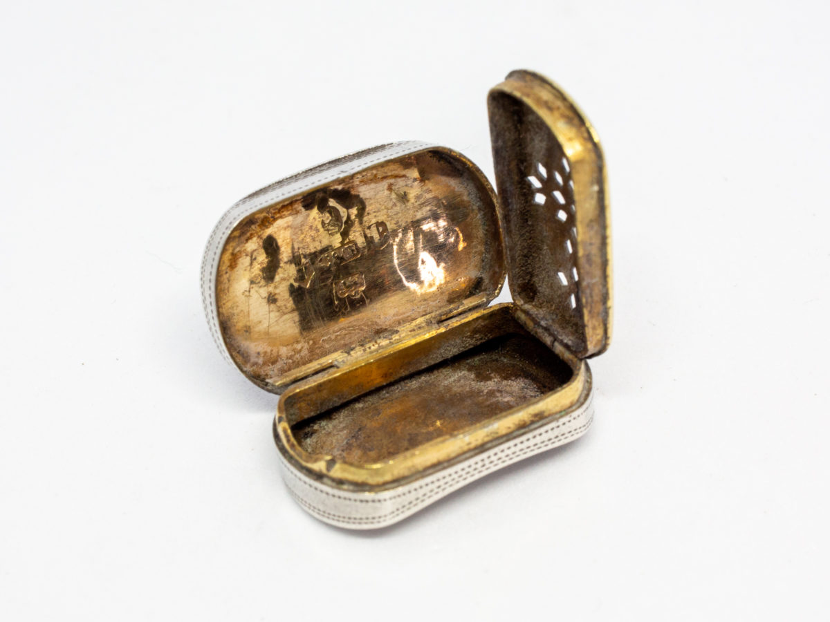 c1807 George III silver vinaigrette. An oblong sterling silver vinaigrette with a curved bottom and a gilt silver interior and grille. Fully hallmarked to the inside of lid for Birmingham assay by silversmith Cocks & Bettridge. A couple of minor dings but closes tight. Photo showing open vinaigrette with grille lifted upright