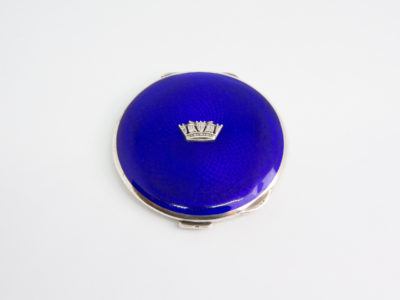 Early George VI silver enamel compact. Sterling silver naval sweetheart ladies compact with guilloche enamel to the lid. Fully hallmarked on the inside for Birmingham assay c1939 and made by John William Barrett. A few minor dinks to the bottom and shallow scratches to the lid, the mirror is in near perfect condition and closes tight. Measures approximately 65mm in diameter. Main photo of compact shown looking down at the royal blue guilloche enamel