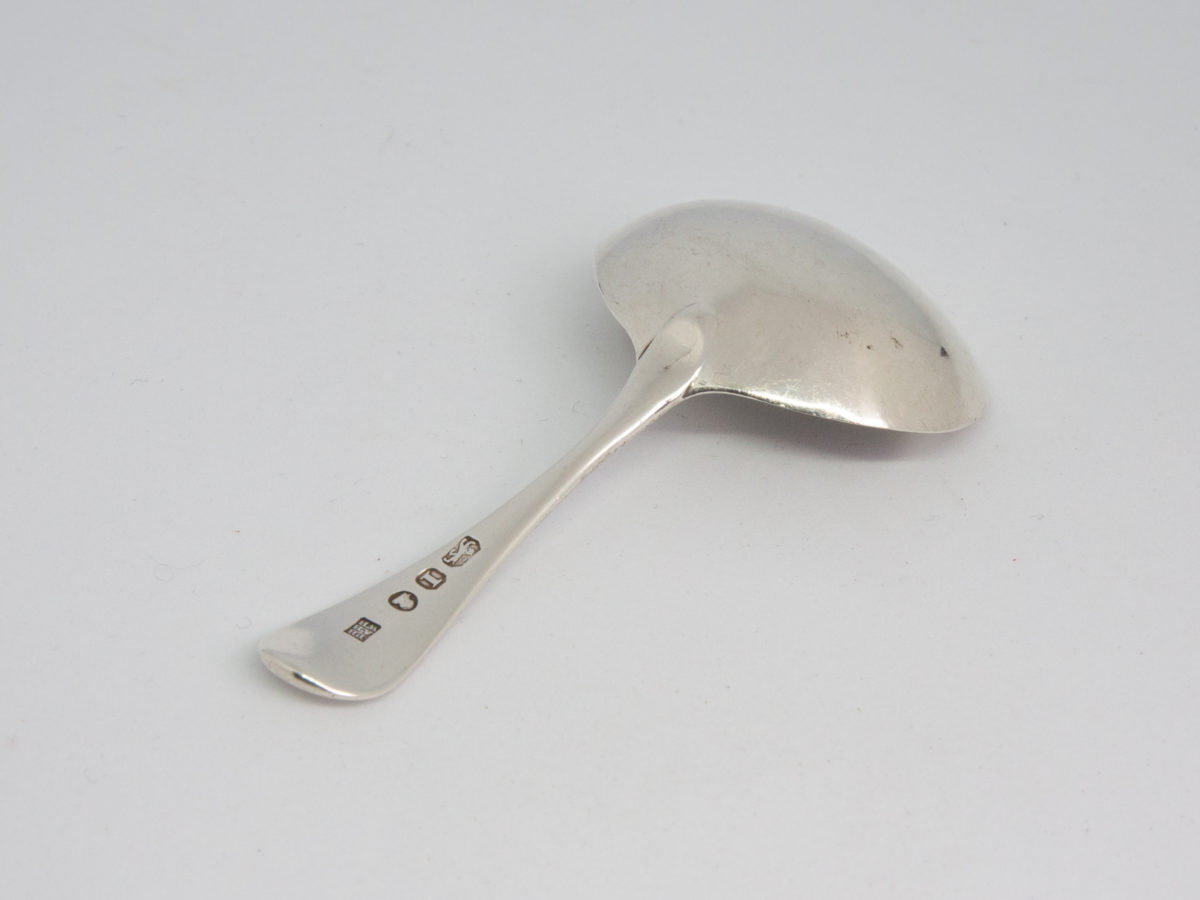c1804 Sterling silver caddy spoon. Antique King George III sterling silver caddy spoon assayed in London by Peter, Ann & William Bateman. Full hallmark to the back of the handle. Caddy bowl measures approximately 46mm by 38mm and 12mm in depth. Photo of spoon with bowl face down showing the hallmark to the tip of the handle. The spoon is laid diagonally with handle tip in bottom left of photo.