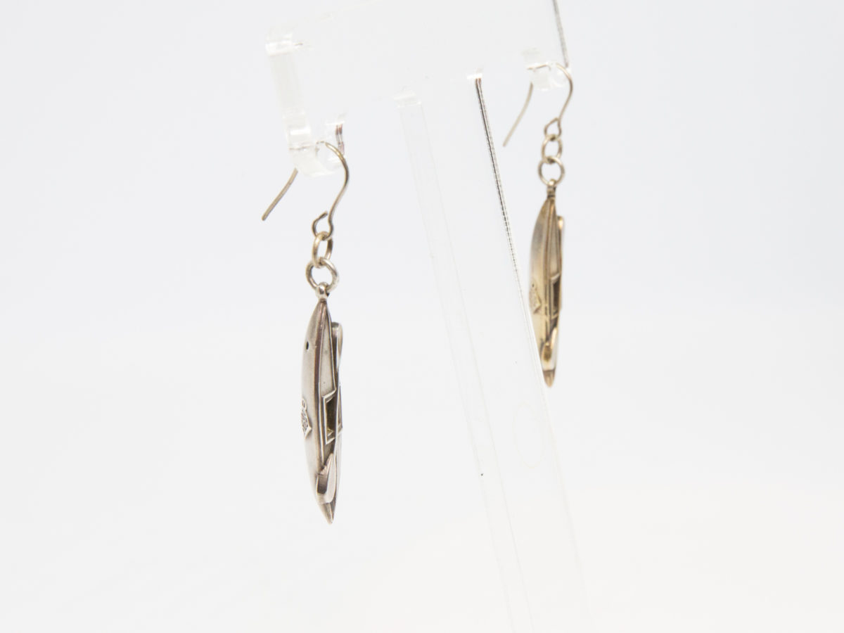 Victorian silver canoe earrings. Very unusual pair of canoe earrings with oar across the top of canoe. One canoe is silver coloured whilst other has slight golden hue and maybe gilded to distinguish 2 sides (Oxford V Cambridge perhaps?) Antique kitemark hallmark to the back of each canoe c1880. (This year being significant in that it is the only time in the history of the boat race that it was postponed for 2 days due to thick fog) Drop length approximately 45mm with canoe measuring approximately 30mm. Earrings weight 2.8gms. Box included. Photo of both earrings on a display stand and seen from a side angle.