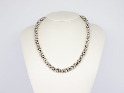 Modern sterling silver necklace. Unusual silver necklace with a bubbles or water droplets like chain. Nice length so closer to neck like a choker. Hallmarked 925 to the link. Main photo of necklace displayed on a stand.