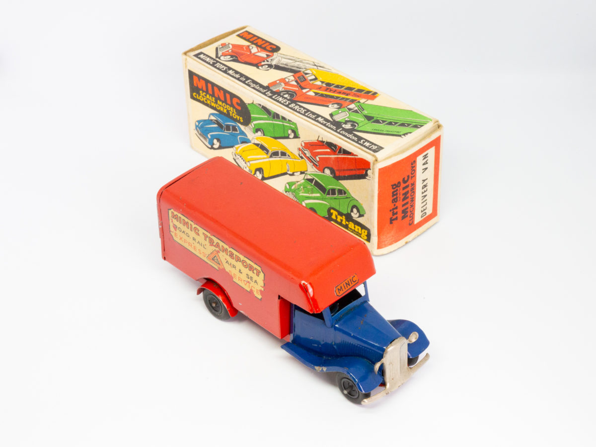 Vintage Minic clockwork delivery van. Wonderful Minic clockwork toy van including original key and box. Van measures approximately 150mm long by 46mm wide and 62mm tall. Photo of delivery van lined up diagonally with its box with van front facing bottom right of photo.