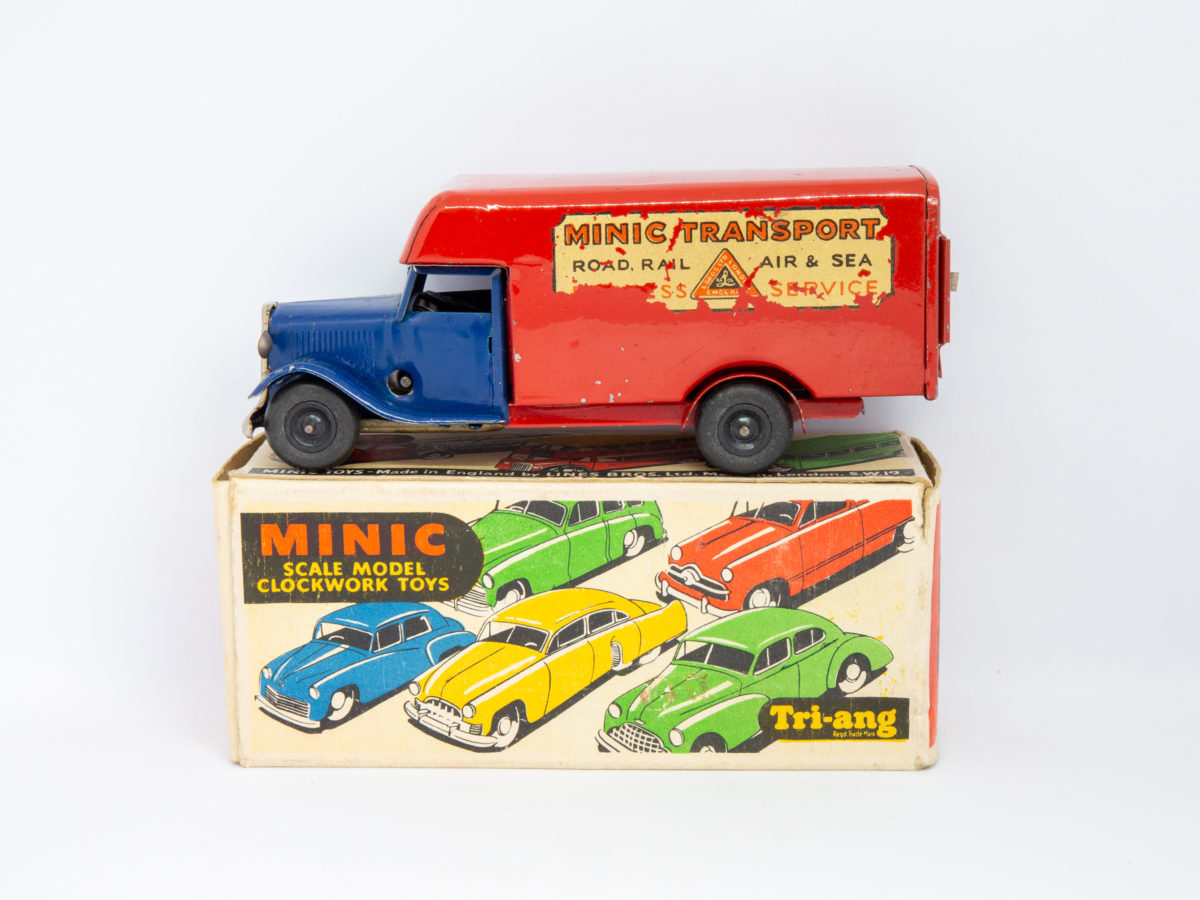 Vintage Minic clockwork delivery van. Wonderful Minic clockwork toy van including original key and box. Van measures approximately 150mm long by 46mm wide and 62mm tall. Photo of van displayed on top of its box from a side angle with van front facing left.