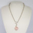 Kit Heath sterling silver and rose quartz necklace. Nice solid silver chain with an attached silver heart and a detachable rose quartz heart. The silver attachment bar is made to resemble an arrow. Rose quartz is believed to attract love and connects to the heart chakra. Detachable heart drop length is 47mm, full drop length of whole pendant area is 53mm. Hallmarked to the clasp, the attached heart and bar of detachable pendant. Main photo of necklace displayed on a stand.