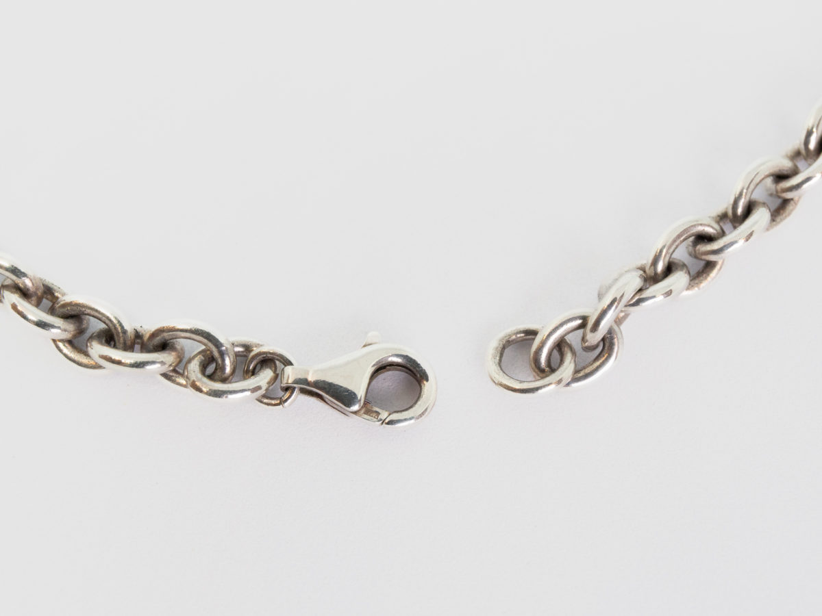 Kit Heath sterling silver and rose quartz necklace. Nice solid silver chain with an attached silver heart and a detachable rose quartz heart. The silver attachment bar is made to resemble an arrow. Rose quartz is believed to attract love and connects to the heart chakra. Detachable heart drop length is 47mm, full drop length of whole pendant area is 53mm. Hallmarked to the clasp, the attached heart and bar of detachable pendant. Close up photo of the clasp area (open).