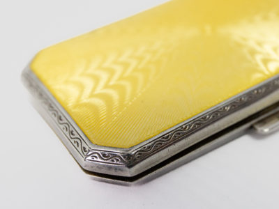 Ladies guilloche enamel and silver cheroot case. Stunning ladies Art Deco cheroot case with yellow guilloche enamel to one side. 925 hallmark for sterling silver in several areas. Gilded interior. In wonderful condition throughout and closes tight. Missing the elasticated band inside. Import mark for Glasgow c1925. Made by Scholl Ltd. Close up photo of one corner of the case enamel side up.