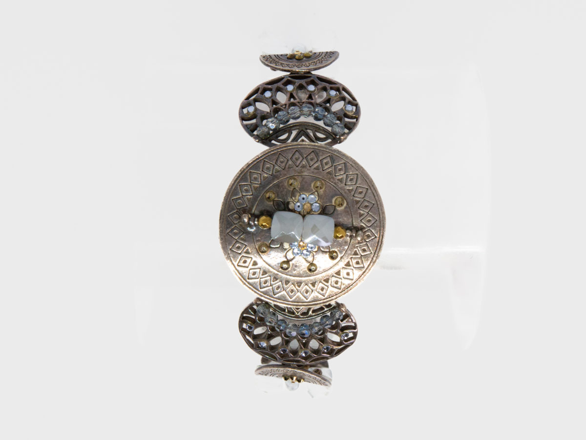 Modern Swarovski bracelet by Taratata. Very pretty bracelet evocative of ancient civilisations. Metal base set with smoky blue and gold Swarovski crystals. Made in France. Central disk measures approximately 37mm in diameter. Picture of the bracelet with circular centre adorned with stones facing the front.