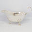 Vintage sterling silver cream or sauce jug. Simple but elegant jug with scallop detail to the legs and an open curl handle. Full hallmark to the base for Birmingham assay and made by Elkington & Co c1938. Main photo of jug seen from a near eye level angle with spout to the left and handle to the right of photo.