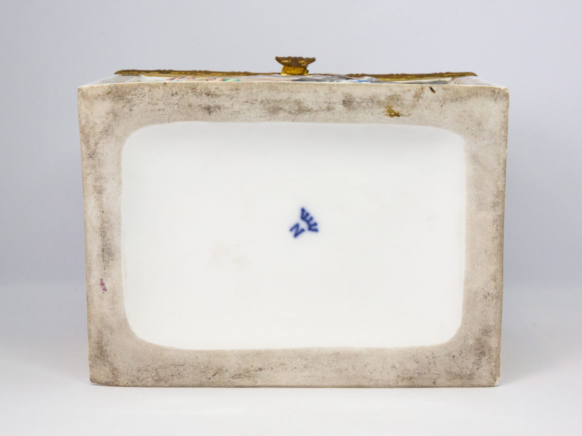 Late 19th century Naples porcelain box. A heavy porcelain box moulded in high relief with scenes of scantily clad men and women disporting themselves in various ways. Beautifully hand-painted in bright vibrant colours and finished off with gilt accent. Photo showing the makers mark on the base of box.