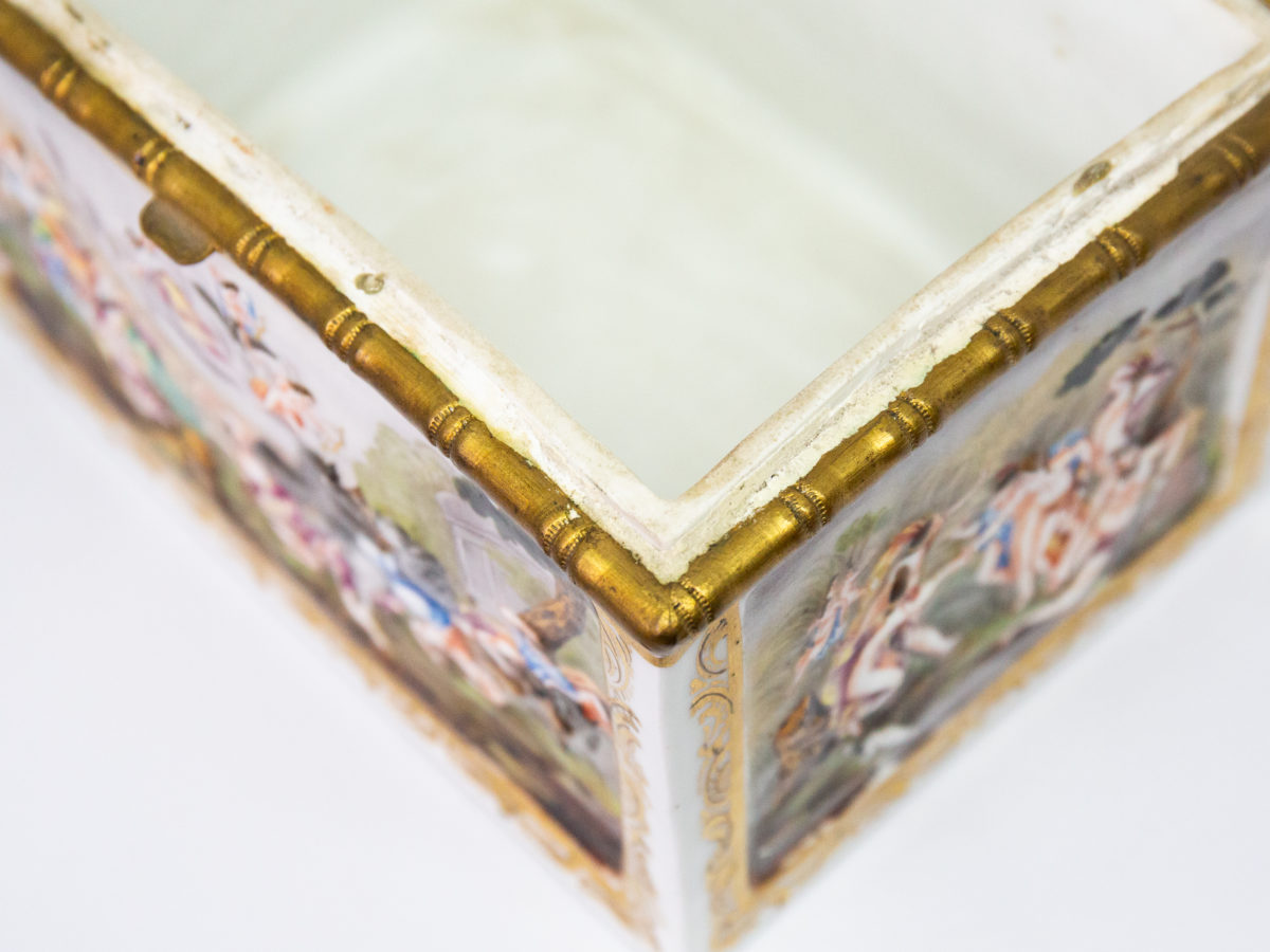 Late 19th century Naples porcelain box. A heavy porcelain box moulded in high relief with scenes of scantily clad men and women disporting themselves in various ways. Beautifully hand-painted in bright vibrant colours and finished off with gilt accent. Photo of one corner of inside box