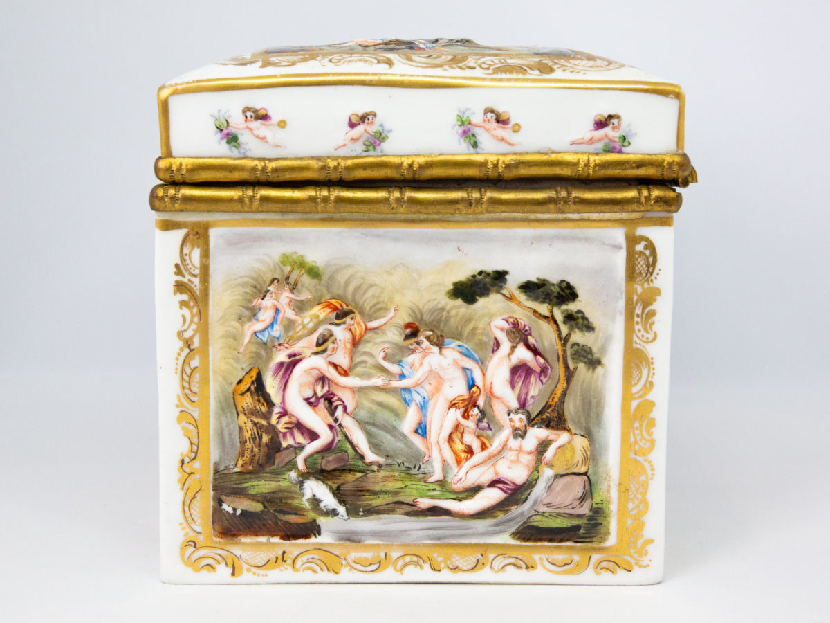 Late 19th century Naples porcelain box. A heavy porcelain box moulded in high relief with scenes of scantily clad men and women disporting themselves in various ways. Beautifully hand-painted in bright vibrant colours and finished off with gilt accent. Photo of side of box. Decoration shows bathing scene by a river.
