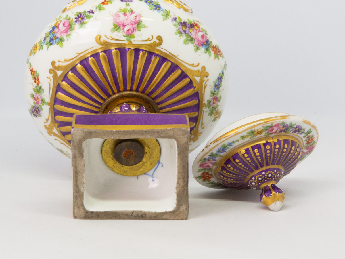Antique Sèvres 2 handled urn with lid. Beautifully handmade and hand-painted Sèvres urn with 2 handles and lid in royal purple and gilt with floral design throughout. Some gilt wear mostly on the rim of the lid otherwise in excellent condition. Late 19th century. Base measures 55mm square, width at widest across handles 130mm, opening at top 72mm in diameter. Photo of base of urn with part of makers mark visible and lid laid to the right-painted side shown.