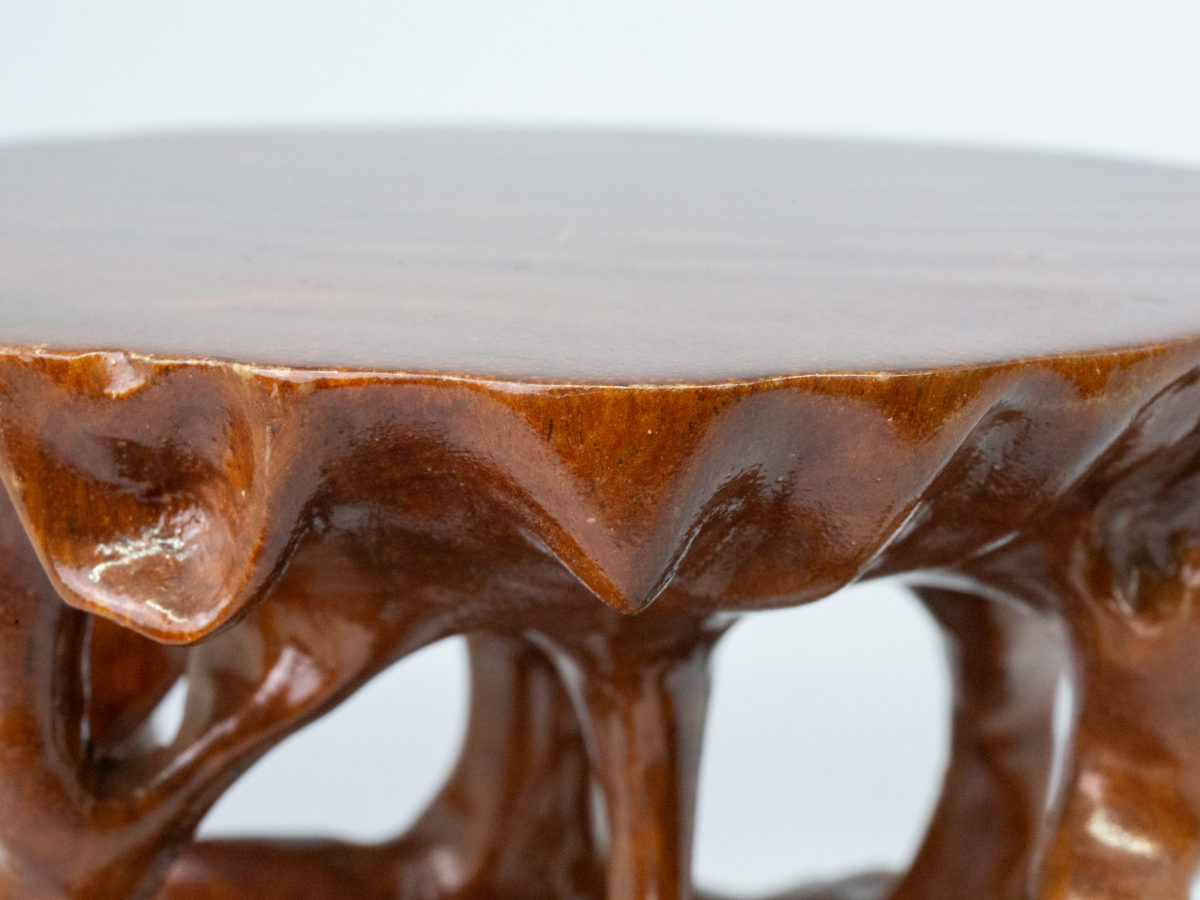 Vintage Chinese carved root stand. A carved hardwood root form stand finished in a hard wearing glossy varnish. Some minor scuff marks to the flat top. Measures 145mm long and 135mm wide at base. Flat top area measures 140mm at longest and 125mm at widest. Photo of one edge of the flat surface area.