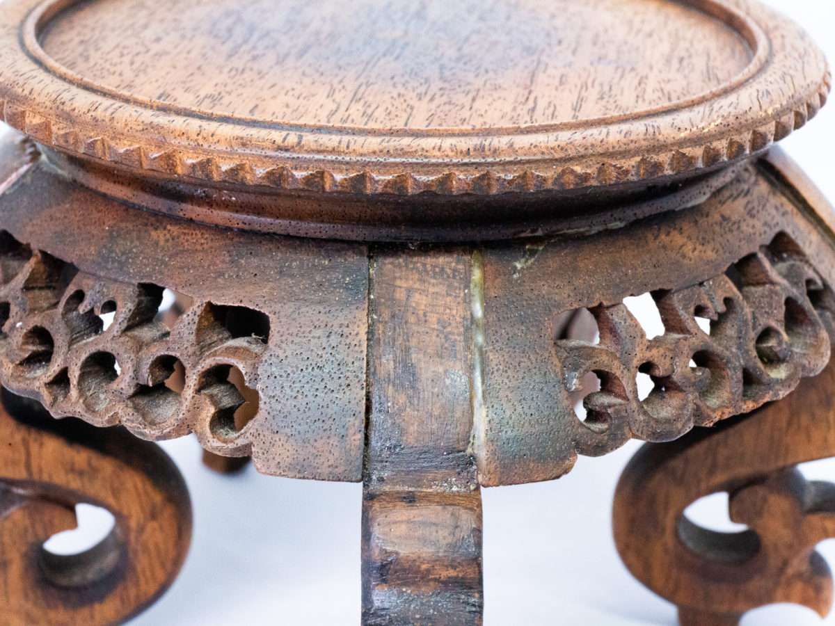 Vintage carved Chinese wooden stand. A nice sized Chinese stand in natural wood with lovely carved detail to the skirt under the stand and to the legs. Some repair work has been carried out as shown on photos. Outer diameter of top area measures 126mm and inner diameter measures 103mm. Widest area at top of legs measures 165mm. Another photo of the repaired area.
