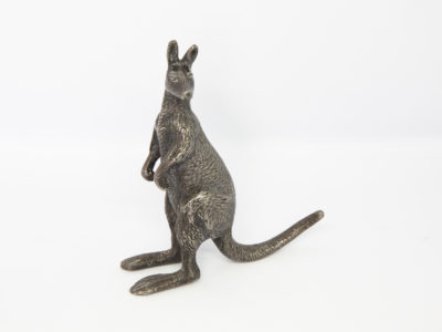 Antique Stewart Dawson kangaroo ornament. A small heavy kangaroo in standing position by Stewart Dawson. Assumed solid silver plate although no visible hallmarks whatsoever. Signed Stewart Dawson to the base of tail. c1900s Measures 85mm at longest from tip of foot to tail, 28mm at widest across hips and 98mm at tallest from ground to tip of ear. Main photo of kangaroo posed slightly off to the side with tail pointing top right and kangaroo facing bottom right of photo.