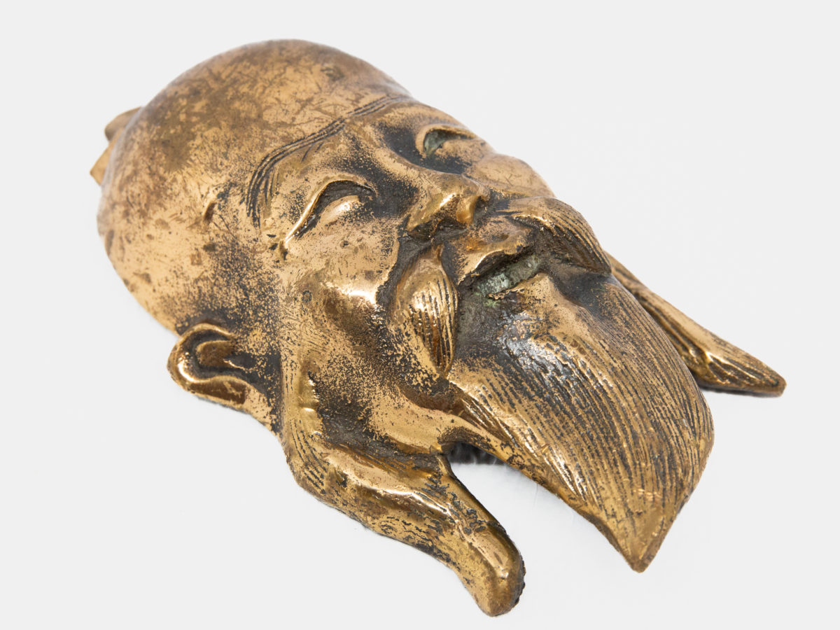 19th century Chinese bronze head. A very heavy and well made bronze head of a Chinese man (possibly deity Shou or Juroujin) in a brass finish. No markings. Attachment for hanging attached. Drop length 185mm. Photo of head displayed diagonally across page so top of head is in top left of photo and beard is in bottom right.