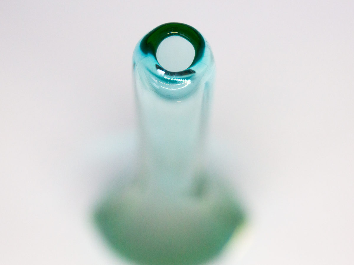 Vintage turquoise glass vase by Murano. Striking slender sommerso glass vase by Murano in stunning turquoise with vibrant sea green to the lower sides. The aesthetically stunning shape is akin to a drop of water and is very pleasing to the eye. A wonderful vintage glass art attributed to Flavio Poli. c1960s. Base measures 42mm by 30mm, the bulbous lower are measures 90mm wide by 60mm deep and top measures 12mm in diameter. The opening at top is very small measuring approximately 6mm in diameter. Photo of top of the vase showing the narrow opening.