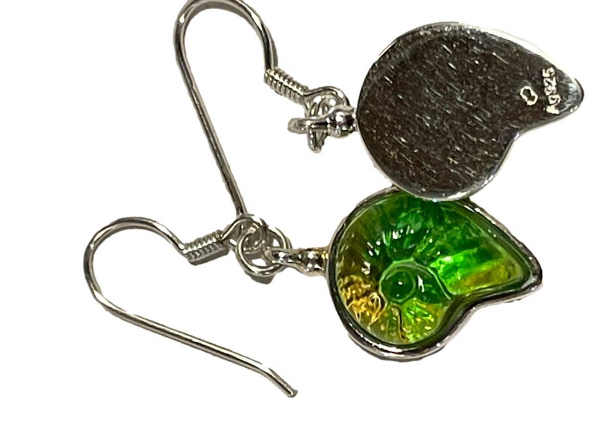 "Sound of the Ocean" earrings by Liuli Gong Fang. Made in sterling silver and green pâte-de-verre crystal in the form of a shell. Drop length approximately 40mm. Photo of earrings on a flat surface with one facing forward and other showing the back with the hallmark.