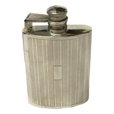 A vintage solid silver hip flask with a hinge bayonet twist cap and engine turned decoration . It is stamped sterling silver to base and weighs 120 grams. There is some slight scratches to top of bayonet arm. There is a vacant panel for a small inscription. Main photo of flask seen from the front and showing the vacant panel.