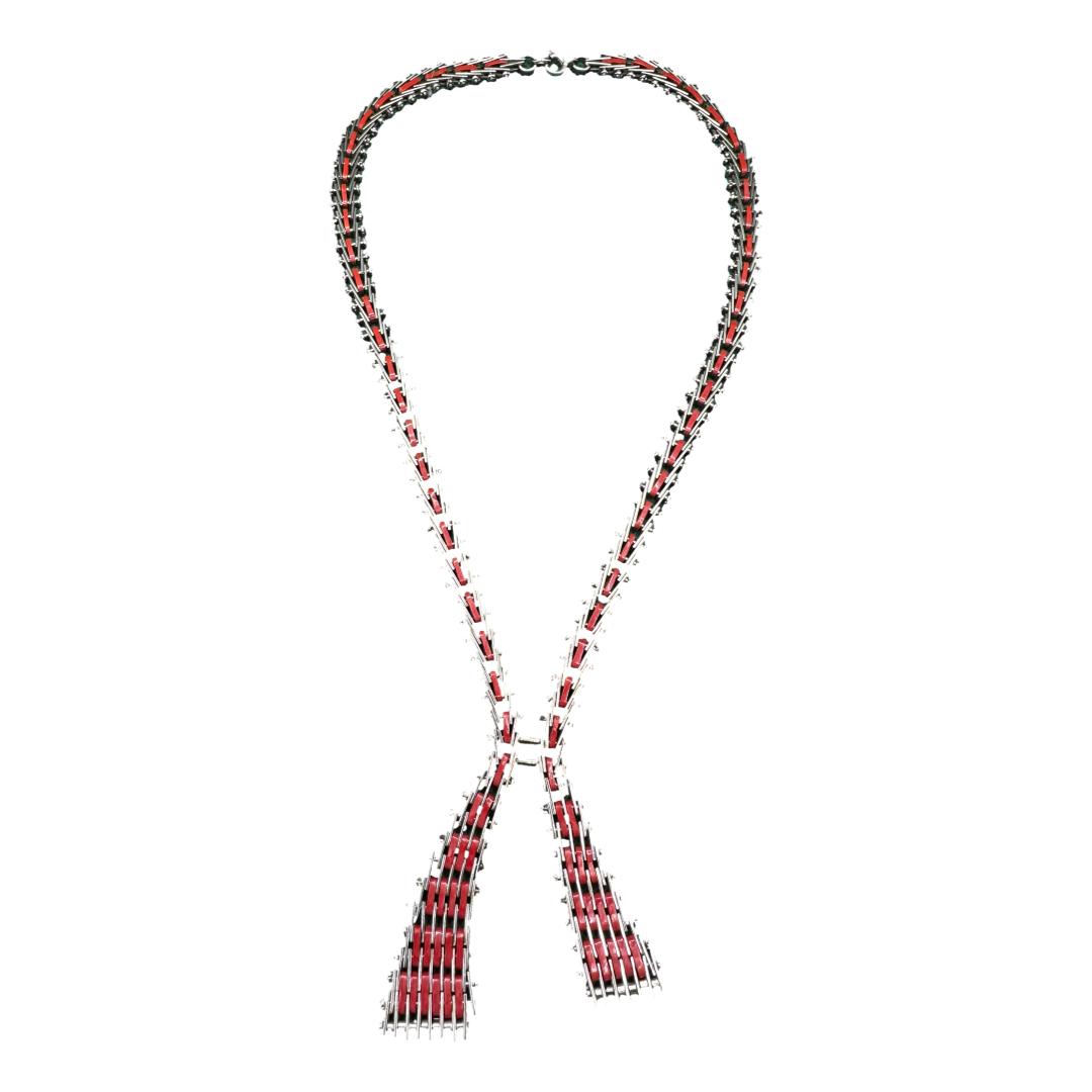 A striking Art Deco unsigned Jakob Bengel Mauerwerk chrome enamel necklace. The total length of the necklace when folded is 600mm. The smallest width is 8mm and the largest width is 20mm. Main photo of necklace in its entirety. There is some green tints to the necklace which is just a reflection of the background used when photographing. Although the necklace gives an impression of a ribbon with loose ends, it is very steampunk in its creation almost like something put together in a garage using nuts and bolts with red enamel embellishment!