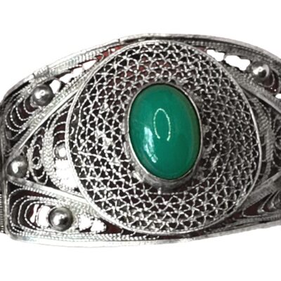 An Art Deco silver filigree bracelet. Each panel of the bracelet is stamped with the Egyptian hallmark for 800 silver and the date letter O for the period 1938-1939. There is a green chrysoprase cabochon stone in the centre of each panel. It is secured with push pin closure and weighs 39.8 grams Close up photo of one of the panels and the beautiful green colour of the chrysoprase cabochon. The silver work on the bracelet is incredible detailed and elaborate.