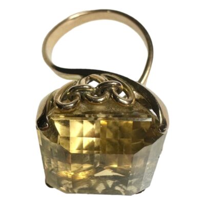 1930s / 40s Large faceted citrine ring set on 14 karat gold. c 1930s-1940s. Ring size O.5.  Dimensions 21mms x 17mms x 11 mms and weight 11.9 grams. Photo of ring seen from a slight height with ring front in the foreground and the loop band in the back. The citrine is huge and beautifully faceted giving extra shine and sparkle.