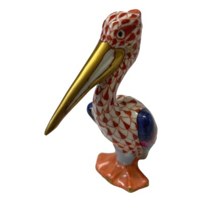 Vintage Herend porcelain pelican in red fish scale pattern. 24karat gold to beak and tips of web feet. Hand-painted and numbered to the base. No.148. Photo of pelican displayed with its large long golden beak pointed to the bottom left corner of the photo. Turned slightly towards camera from main photo.