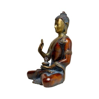 Vintage bronze Buddha. Decorated robes with Vitarka Hand Mudra. Photo of the Buddha seen from a side angle with the front facing towards the left.
